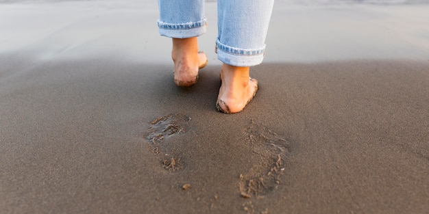 ビーチで砂の上の女性の足