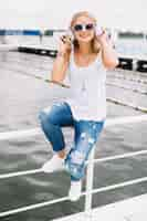 Free photo woman on fence listening to music