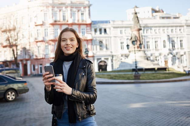 Woman finding her way in city. Portrait of charming caucasian female in trendy outfit walking on street