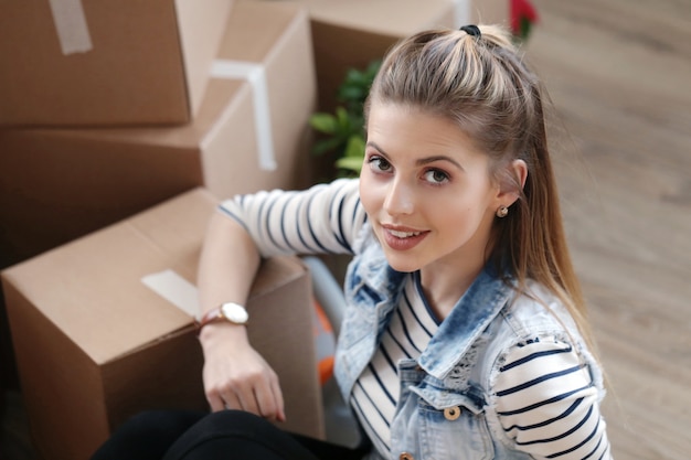 Free photo woman finished with cargo packages and is sitting next to the boxes