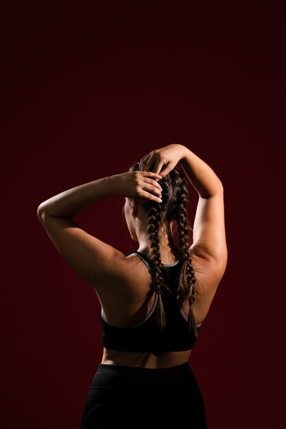 Woman fixing her hair braid tails  from behind