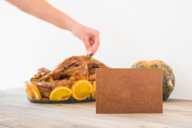 Free photo woman flavouring baked chicken in glassware