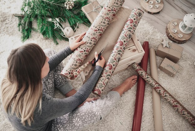 Woman flooring and cutting wrapping paper