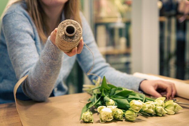 女性の花屋はチューリップの花束を作ります