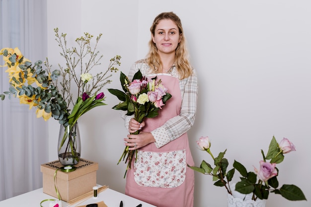 Woman in flower shop holding bunch