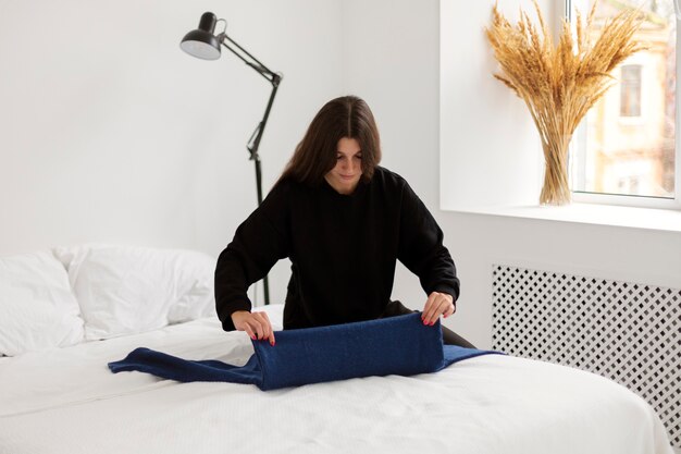 Woman folding clothes medium shot