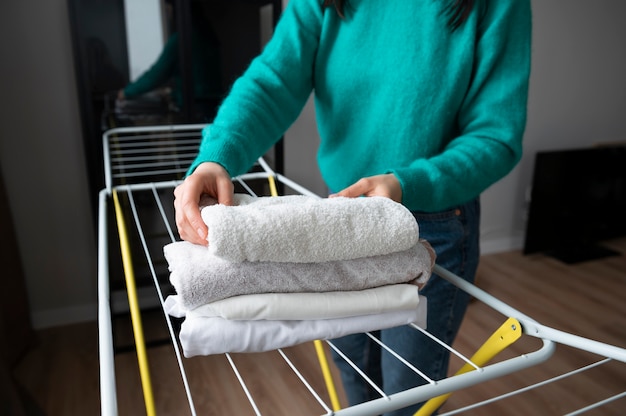 Woman folding towels at home during quarantine