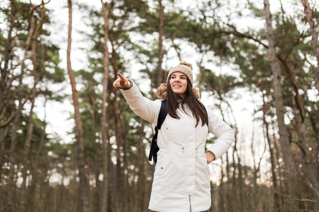 Woman in forest pointing at distance