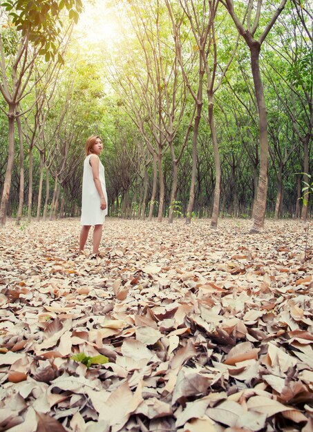 Woman in the forest with ground covered with leaves