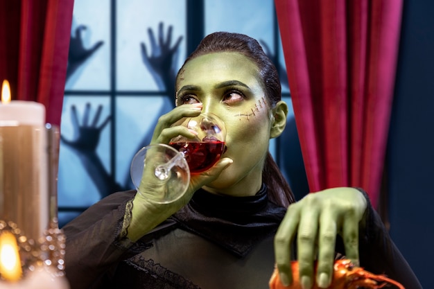 Woman frankenstein with drink front view