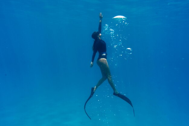 Woman freediving with flippers underwater