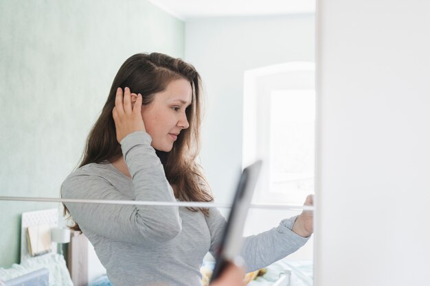 Woman in front of mirror in bathroom