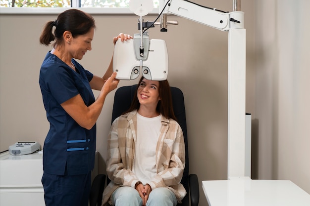 Бесплатное фото Женщина проходит осмотр глаз в кабинете офтальмолога