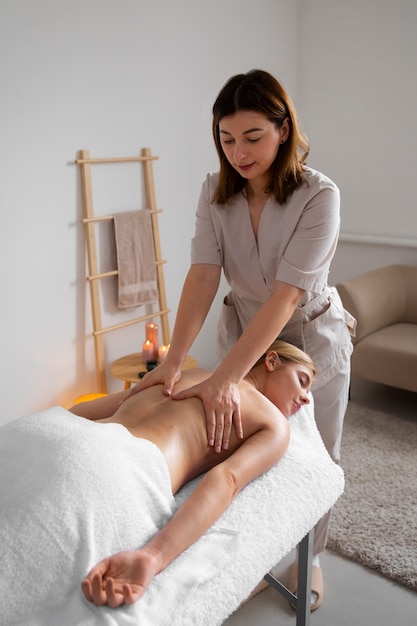 Woman getting a back massage from female masseur