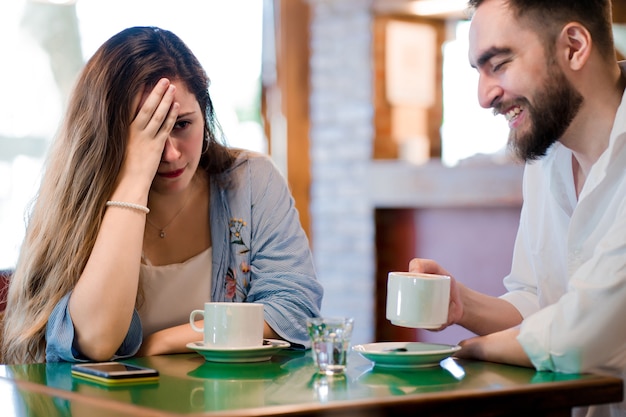 Woman getting bored at a date at a coffee shop.