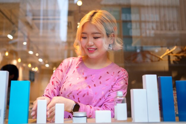 Woman getting the display window of a japanese hairdressers ready