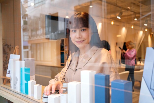 Woman getting the display window of a japanese hairdressers ready