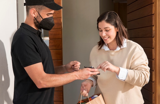 Free photo woman getting a food bag delivered