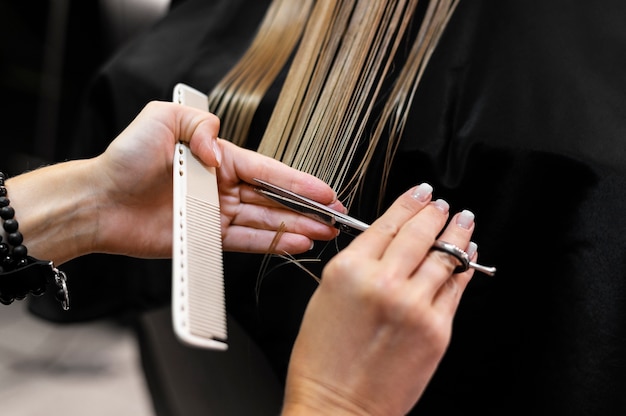 Женщина стрижет волосы в салоне красоты