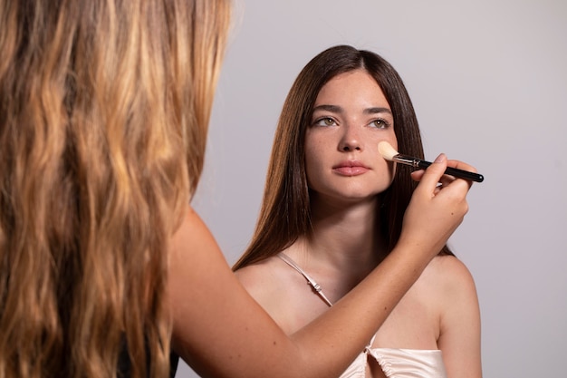 Free photo woman getting her make up done by a professional