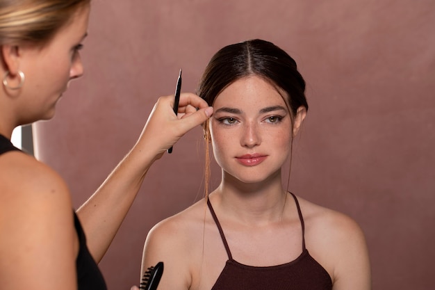 Free photo woman getting her make up done by a professional