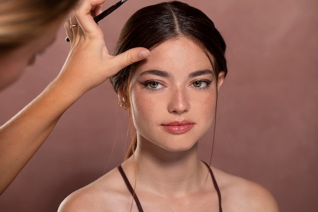 Free photo woman getting her make up done by a professional