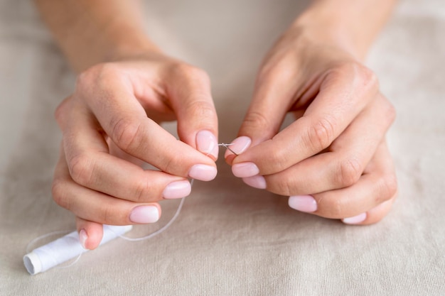 Woman getting thread into needle