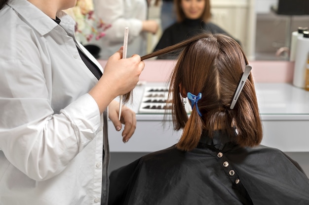 Woman getting treatment at hairdresser shop