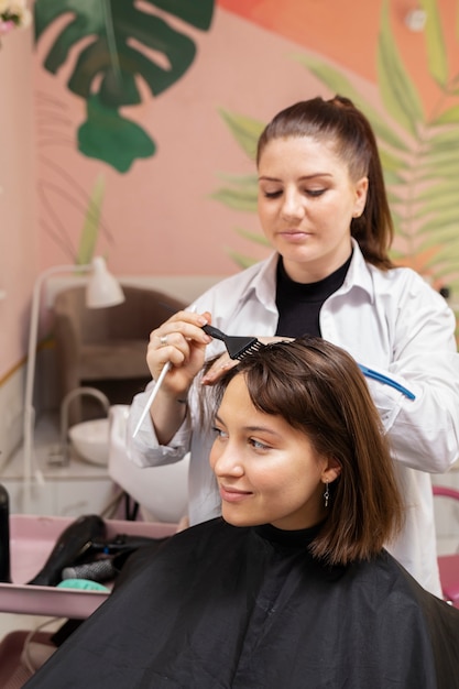 Woman getting treatment at hairdresser shop