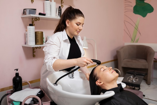 Woman getting treatment at hairdresser shop