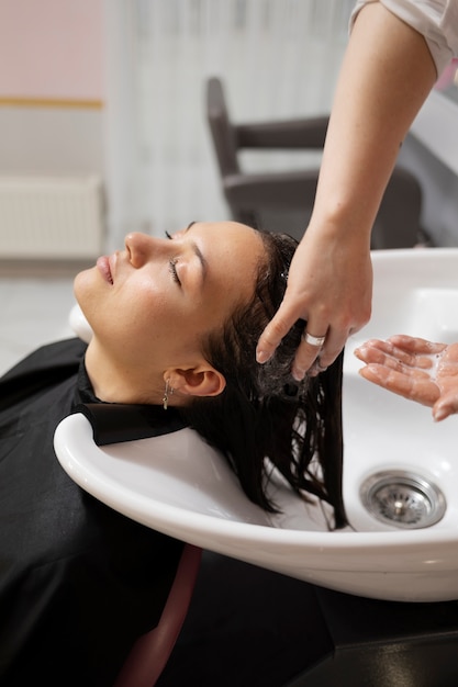 Woman getting treatment at hairdresser shop