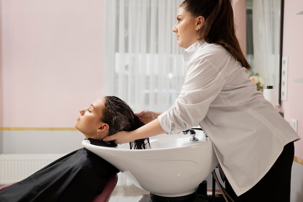 Woman getting treatment at hairdresser shop