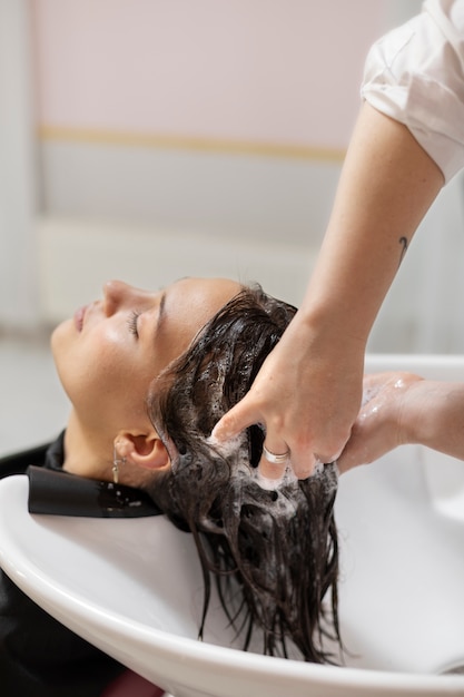 Woman getting treatment at hairdresser shop