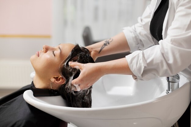 Woman getting treatment at hairdresser shop