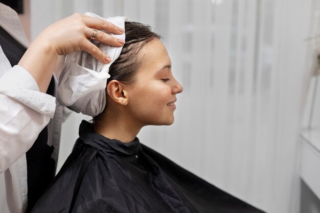 Woman getting treatment at hairdresser shop