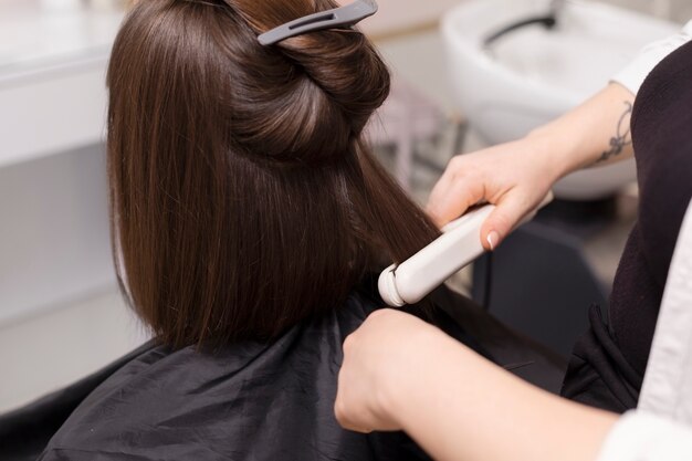 Woman getting treatment at hairdresser shop