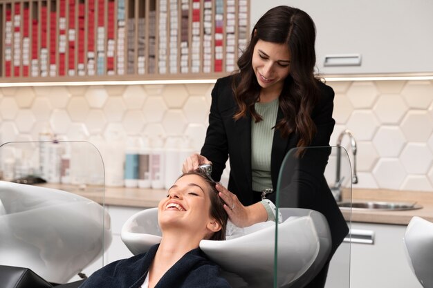 Woman getting treatment at hairdresser shop