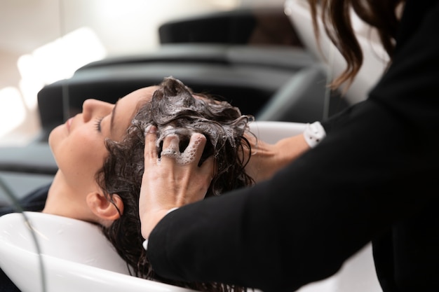 Woman getting treatment at hairdresser shop