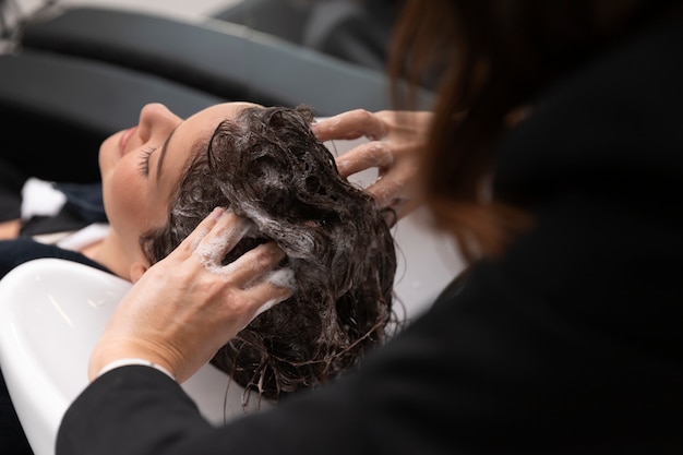 Woman getting treatment at hairdresser shop