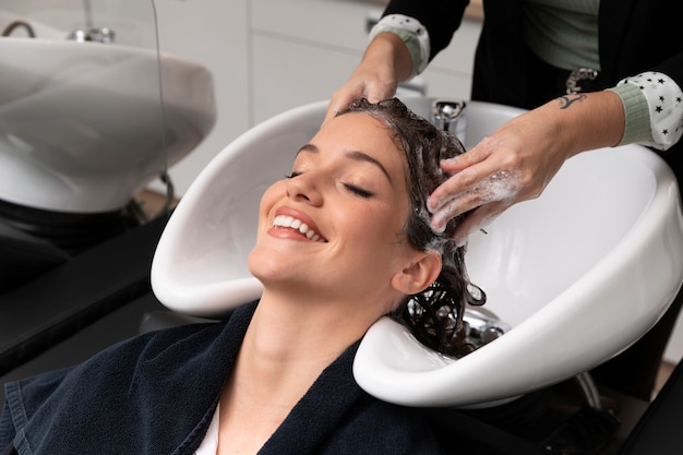 Woman getting treatment at hairdresser shop