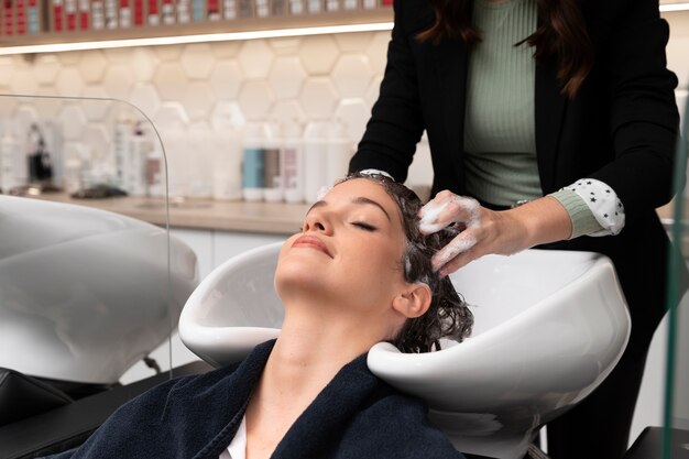 Woman getting treatment at hairdresser shop