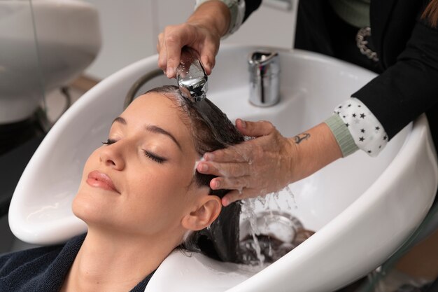 Woman getting treatment at hairdresser shop