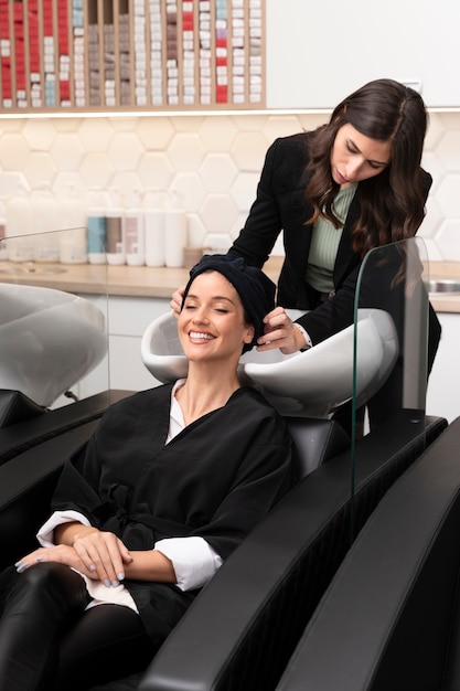 Woman getting treatment at hairdresser shop