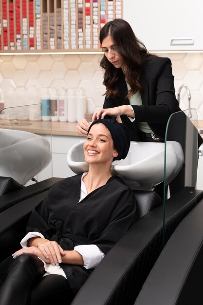 Woman getting treatment at hairdresser shop