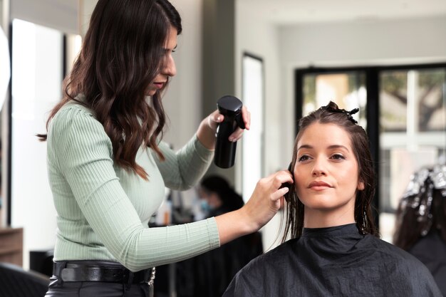 Woman getting treatment at hairdresser shop