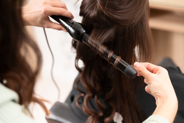 Woman getting treatment at hairdresser shop