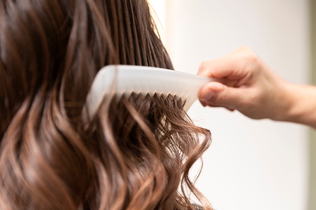 Woman getting treatment at hairdresser shop