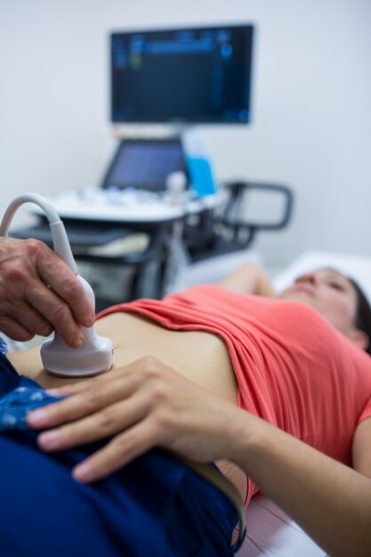 Woman getting ultrasound of a abdomen from doctor