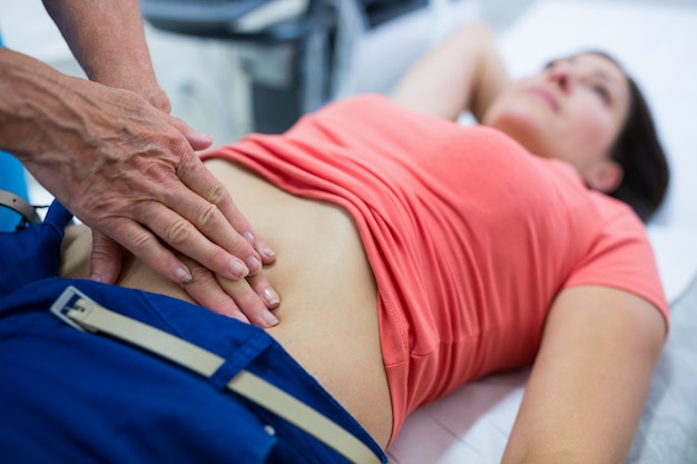 Woman getting ultrasound of a abdomen from doctor