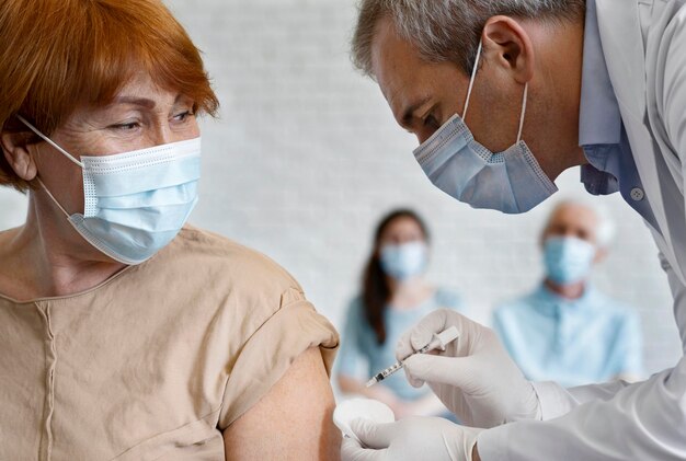 Woman getting vaccine shot by male medic